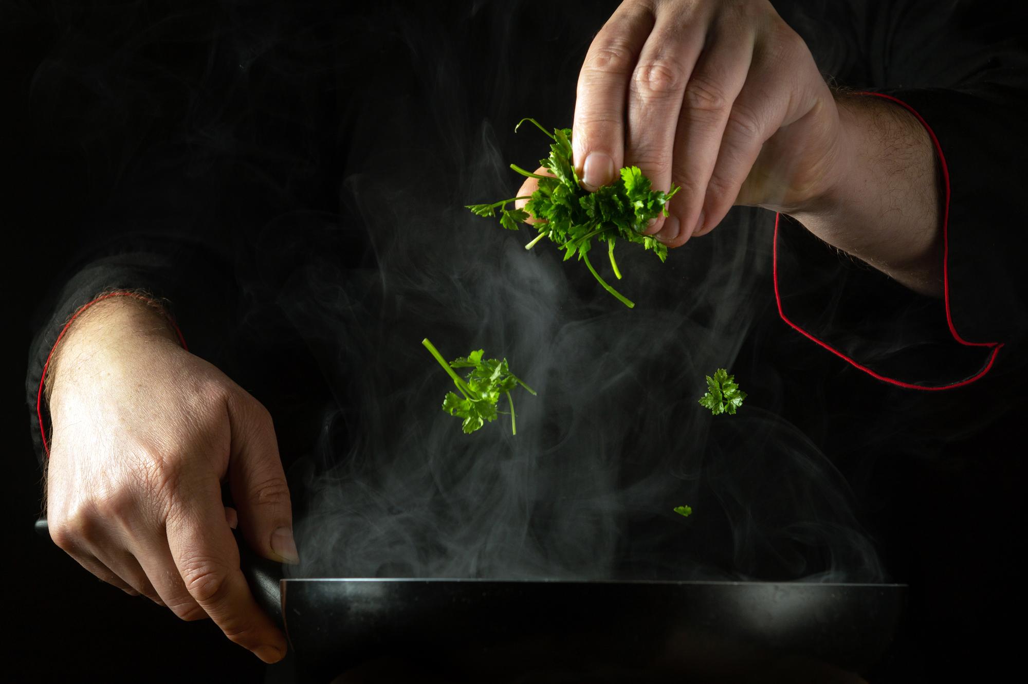 Close-up of chef's hands garnishing